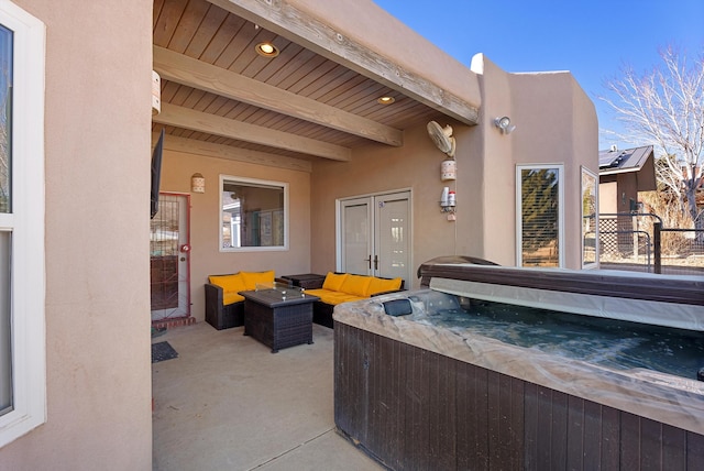 view of patio with an outdoor living space and a hot tub