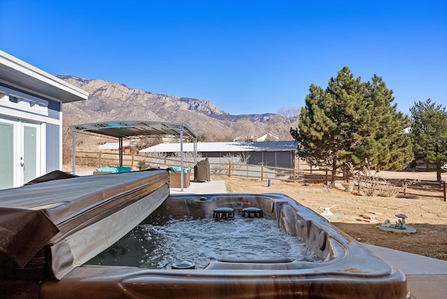 exterior space with a mountain view and a hot tub