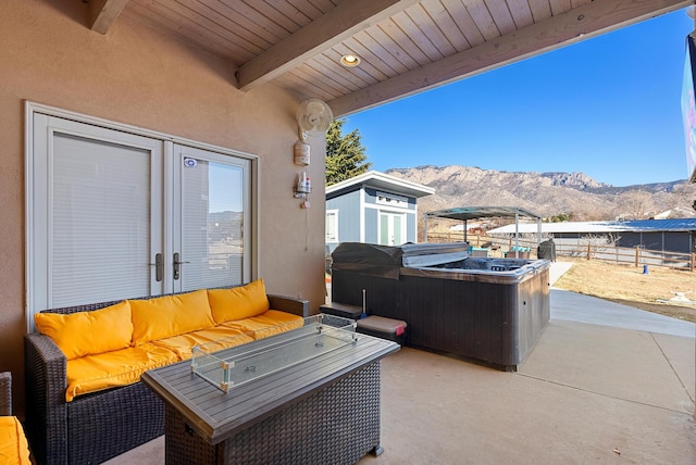 view of patio / terrace featuring a hot tub, a mountain view, and an outdoor hangout area