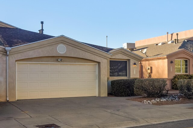 view of front of property featuring a garage and central air condition unit