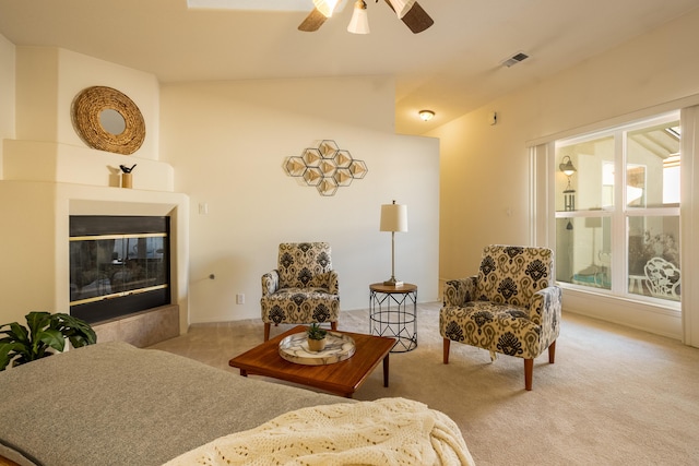 interior space with vaulted ceiling, light colored carpet, and ceiling fan