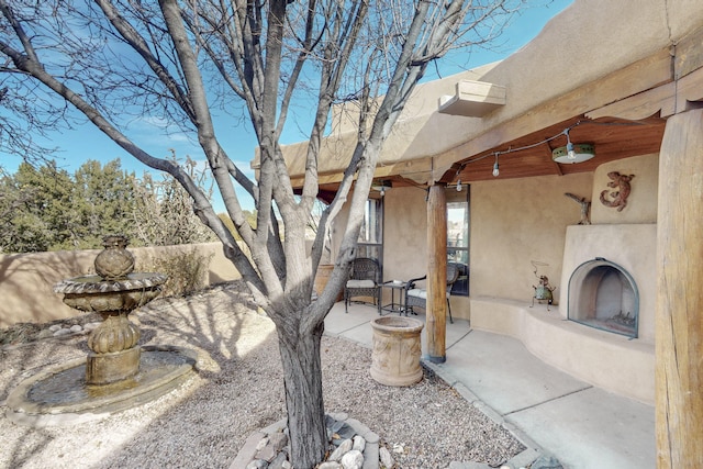 exterior space with exterior fireplace and a patio