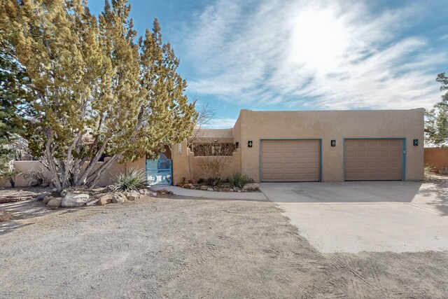 pueblo-style home featuring a garage