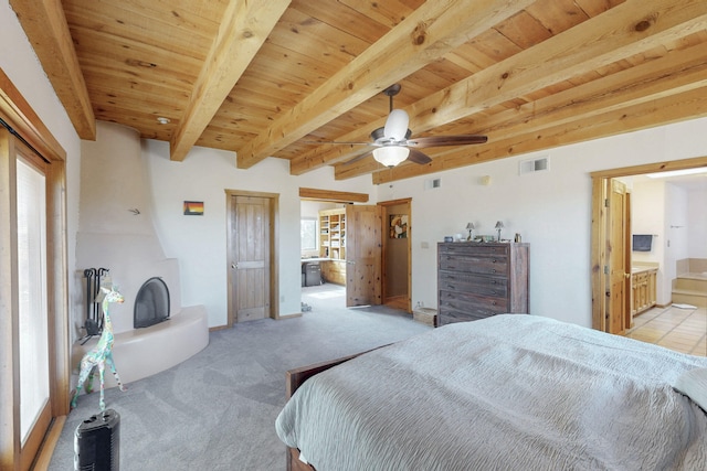 bedroom with connected bathroom, beam ceiling, wooden ceiling, and light colored carpet