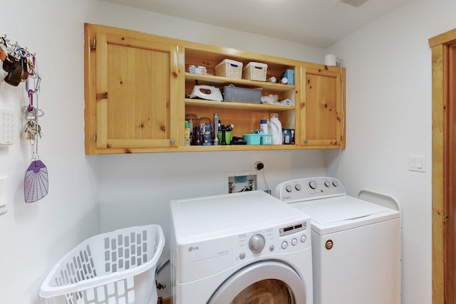 clothes washing area with cabinets and washer and dryer