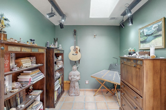 miscellaneous room with rail lighting and light tile patterned floors