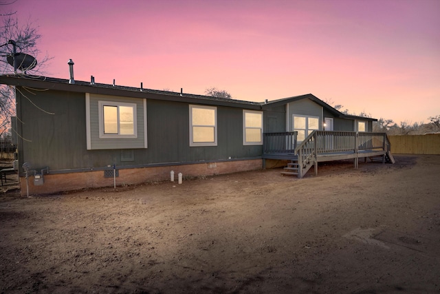 back house at dusk featuring a deck