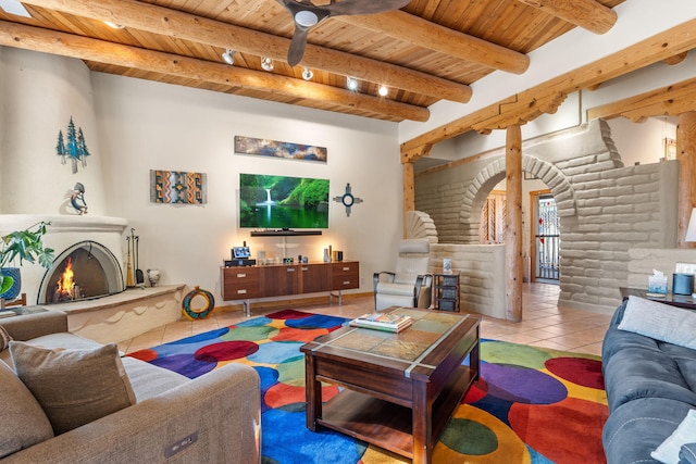 living room featuring light tile patterned floors, wood ceiling, a large fireplace, log walls, and beamed ceiling