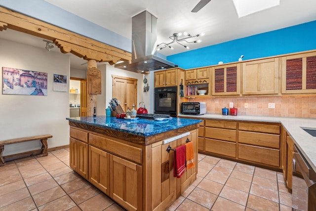 kitchen featuring island range hood, a center island, decorative backsplash, and oven