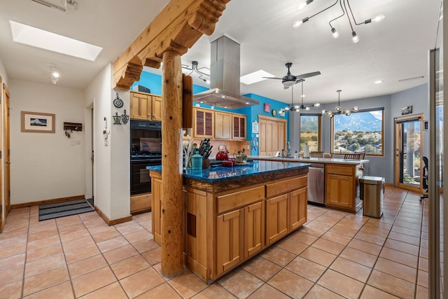 kitchen featuring a kitchen island, island range hood, a skylight, hanging light fixtures, and stainless steel dishwasher