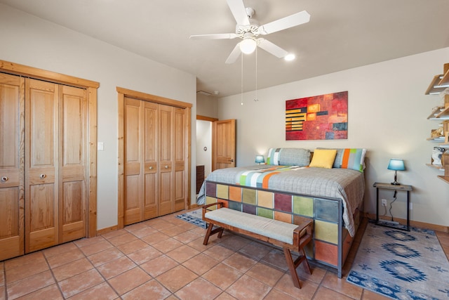 bedroom featuring light tile patterned floors, multiple closets, and ceiling fan