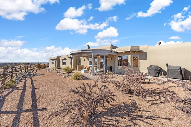 rear view of house with ceiling fan and a patio area