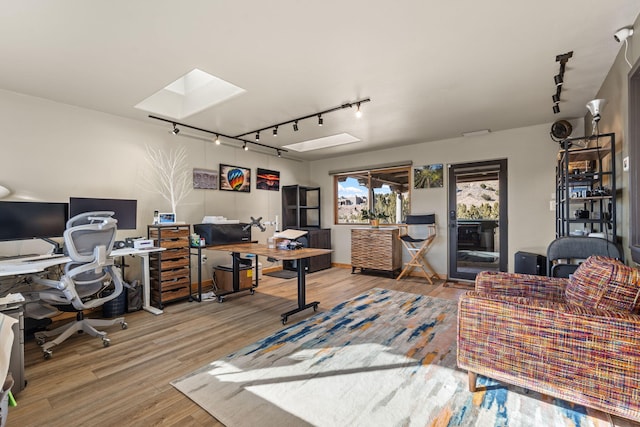 home office featuring a skylight, wood-type flooring, and rail lighting