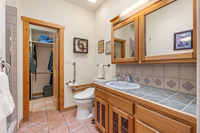 bathroom with tasteful backsplash, tile patterned floors, toilet, and vanity