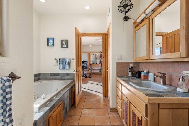 bathroom with vanity, backsplash, tile patterned floors, and tiled bath