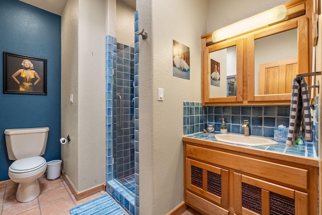 bathroom with vanity, decorative backsplash, tile patterned floors, toilet, and walk in shower