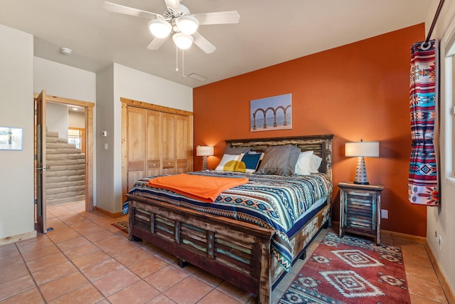 bedroom with tile patterned flooring, a closet, and ceiling fan