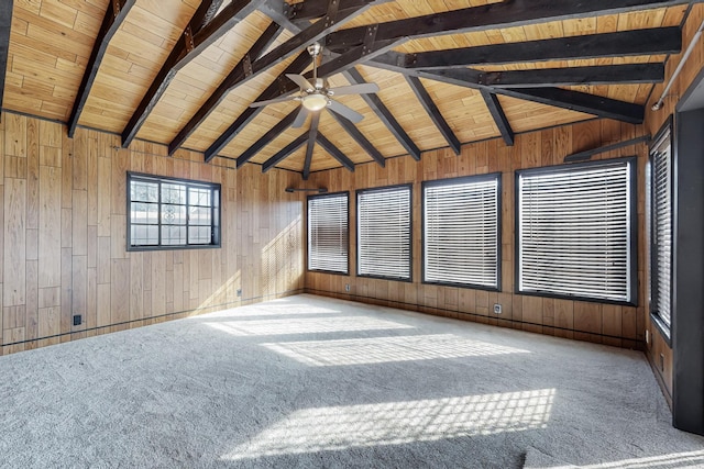 carpeted empty room with ceiling fan, vaulted ceiling with beams, wood ceiling, and wooden walls