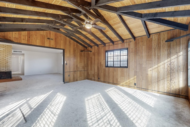 unfurnished living room with vaulted ceiling with beams, wood ceiling, wooden walls, and carpet flooring