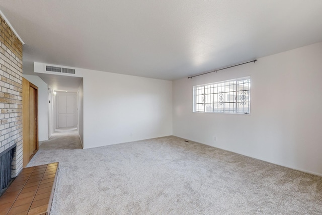 carpeted spare room featuring a fireplace