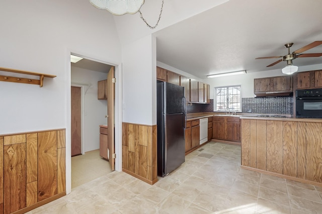 kitchen with sink, ceiling fan, backsplash, wooden walls, and black appliances