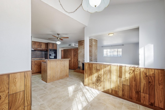 kitchen with decorative backsplash, oven, ceiling fan, and kitchen peninsula