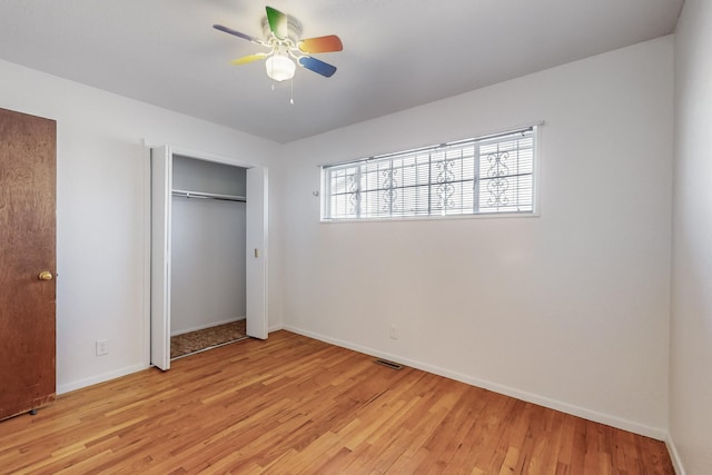 unfurnished bedroom featuring ceiling fan, a closet, and light hardwood / wood-style flooring