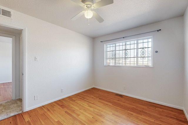 empty room with light hardwood / wood-style floors and ceiling fan