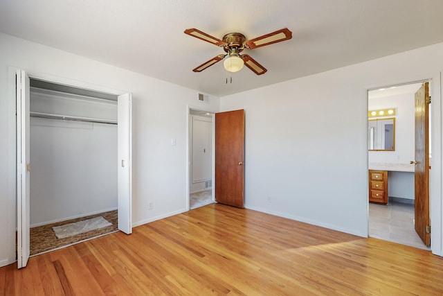 unfurnished bedroom with connected bathroom, a closet, ceiling fan, and light wood-type flooring