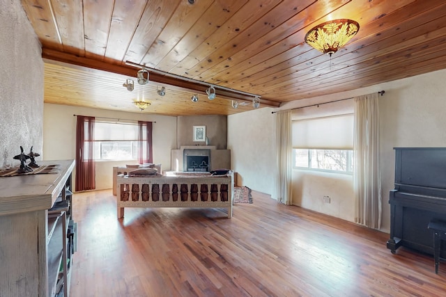 bedroom with track lighting, light hardwood / wood-style floors, and wooden ceiling