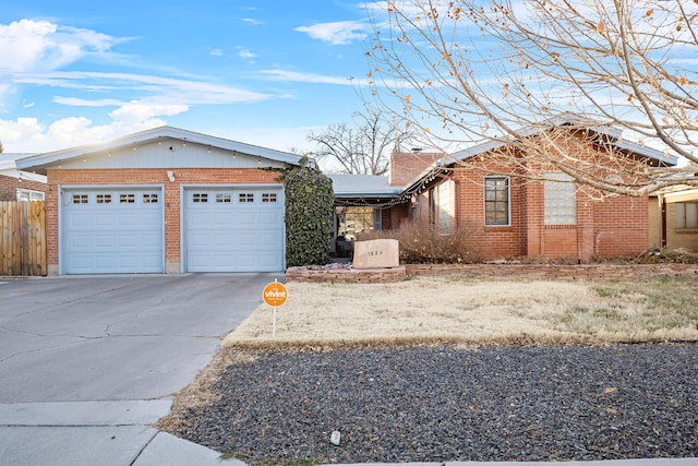 ranch-style house with driveway, a garage, fence, and brick siding