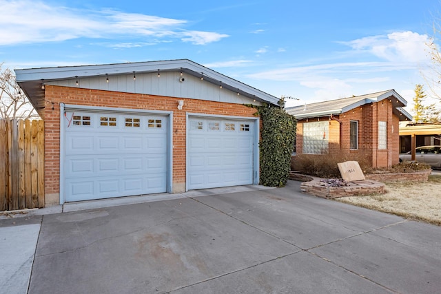 exterior space with a garage, brick siding, and fence