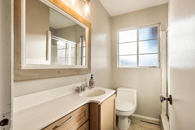 bathroom with vanity, a shower with door, and toilet