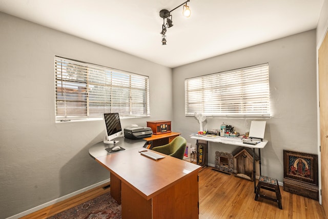 office featuring track lighting and light hardwood / wood-style floors