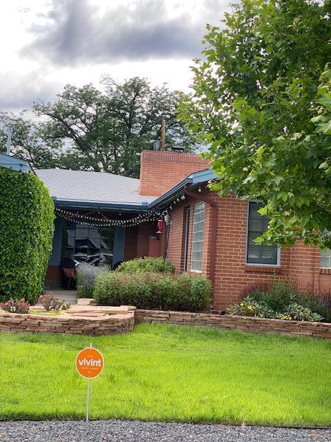 exterior space with brick siding and a front lawn