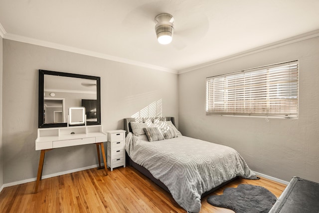 bedroom featuring baseboards, ornamental molding, and wood finished floors