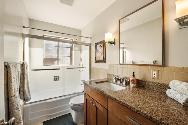 bathroom with tasteful backsplash, visible vents, toilet, combined bath / shower with glass door, and vanity