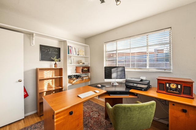 home office featuring baseboards and wood finished floors