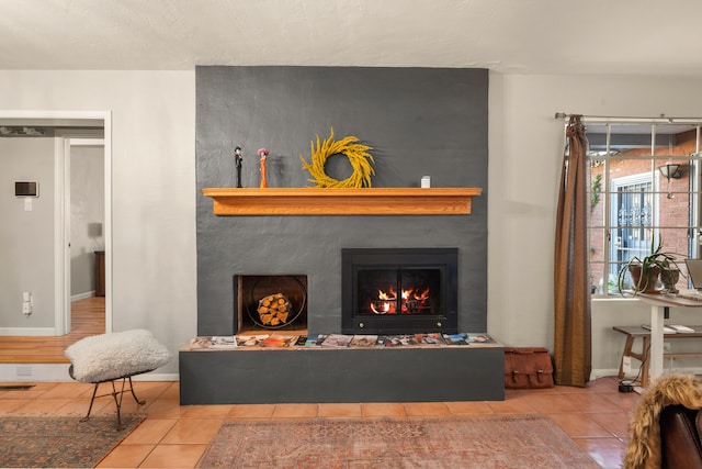 living area featuring tile patterned flooring, a fireplace, baseboards, and visible vents