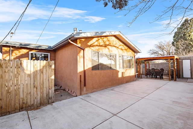 back of property featuring a gazebo and a patio area