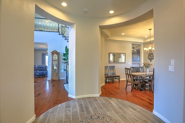 corridor with a chandelier and hardwood / wood-style floors