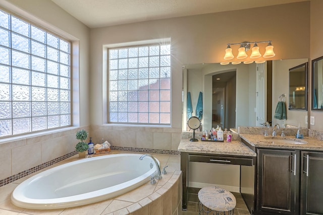 bathroom featuring vanity and tiled bath