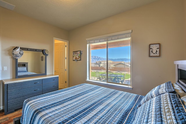 bedroom with dark wood-type flooring and a mountain view