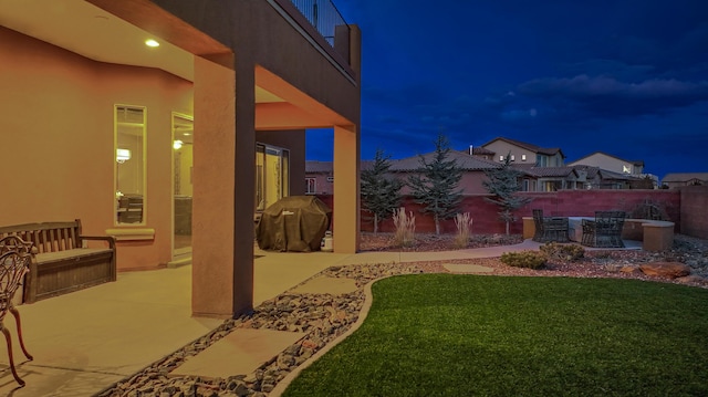 yard at night featuring a patio area