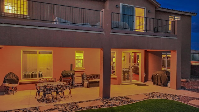 rear view of property featuring a balcony and a patio