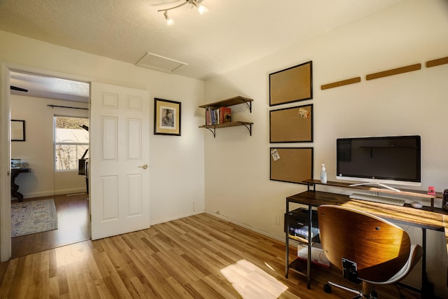 office space featuring a textured ceiling and light hardwood / wood-style flooring