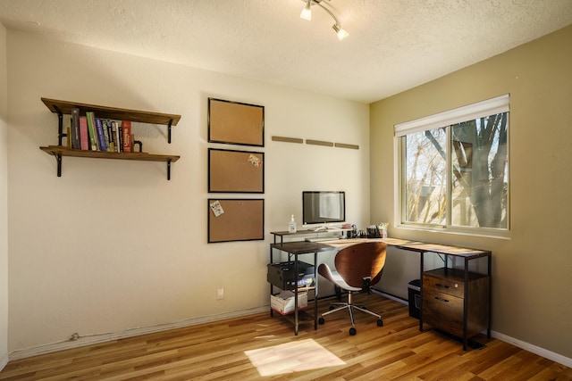 office with a textured ceiling and light hardwood / wood-style floors