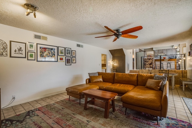 tiled living room featuring a textured ceiling and ceiling fan