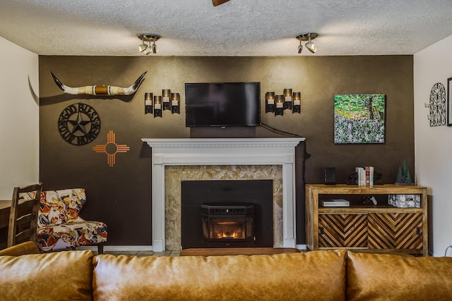 living room with a premium fireplace and a textured ceiling