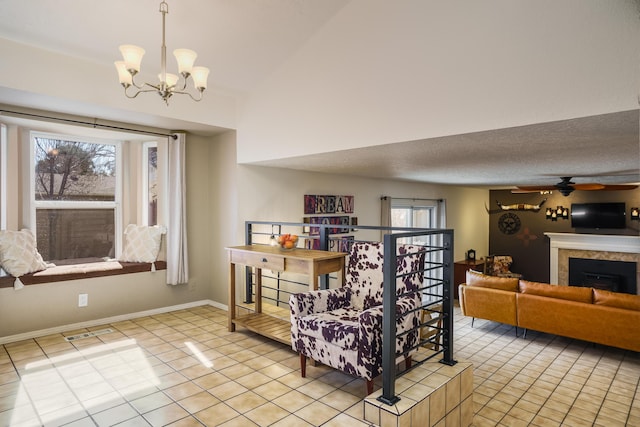 living room featuring a tiled fireplace, ceiling fan with notable chandelier, a textured ceiling, and light tile patterned floors